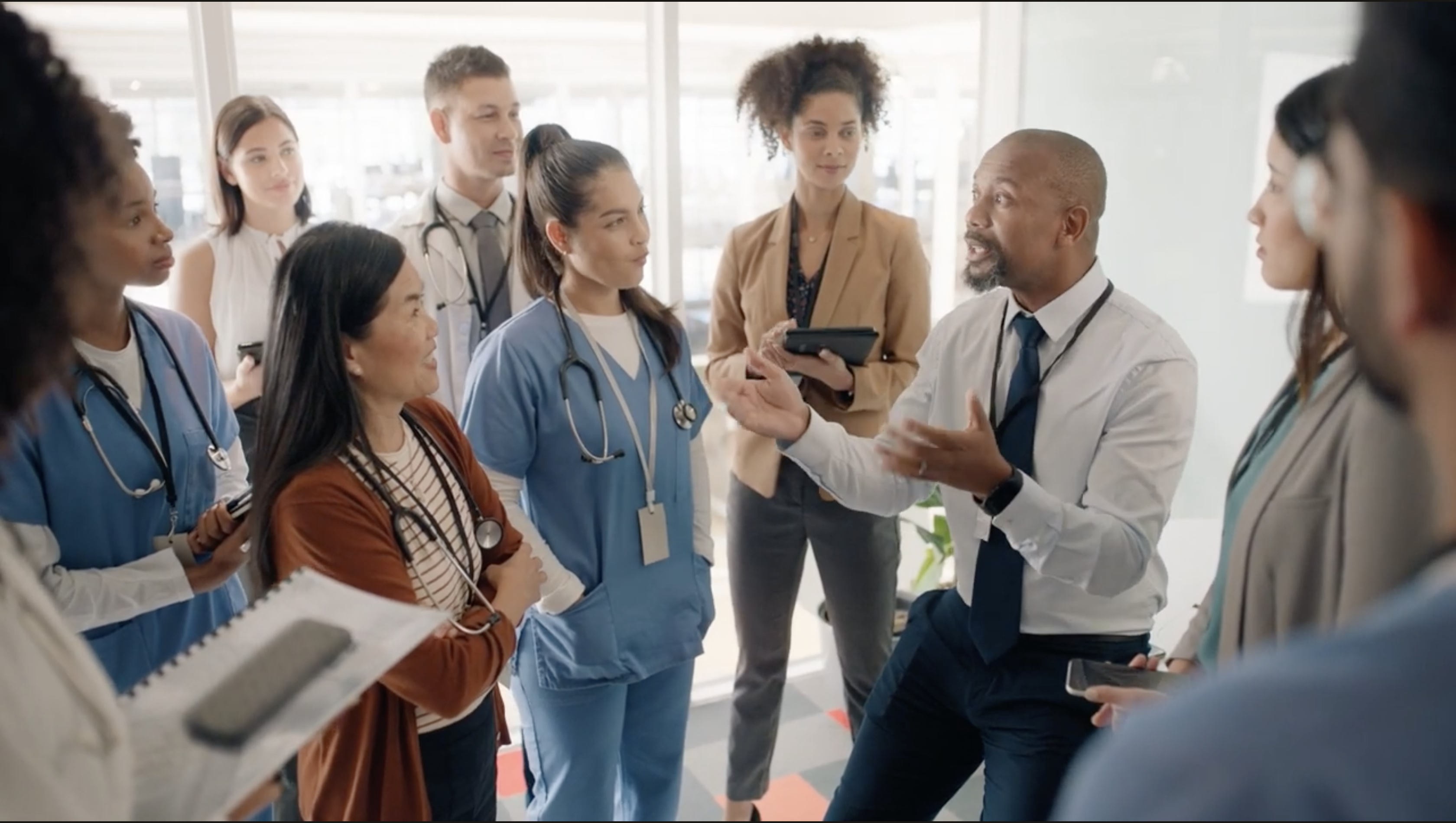 Sitll shot of a group of people in a hospital from the Long Term Care video. 