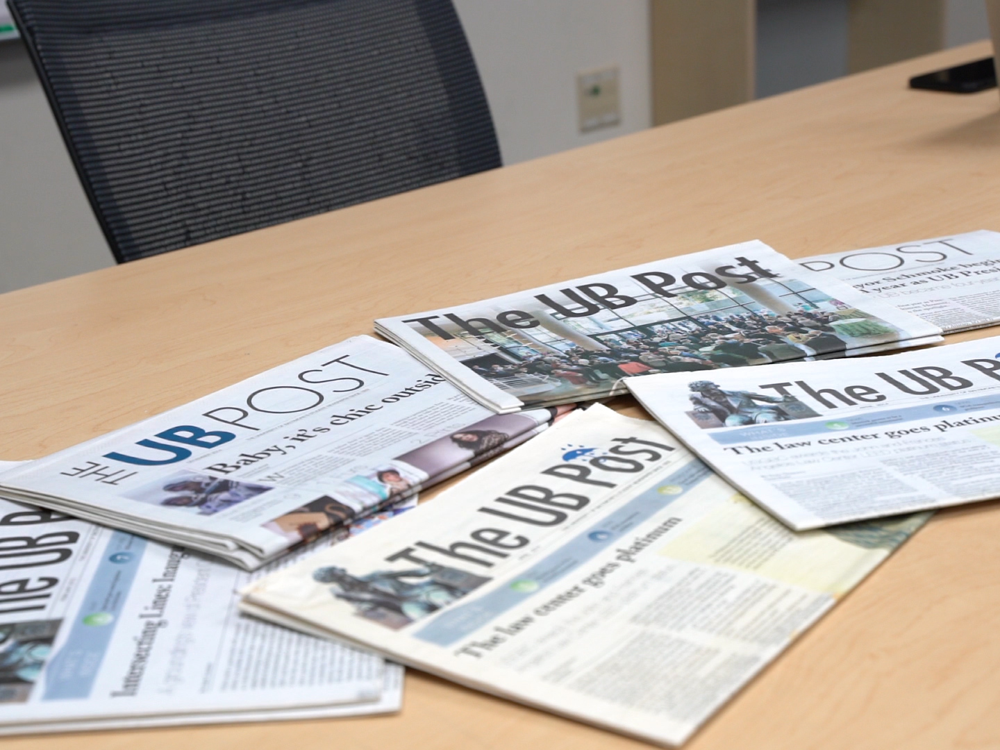 This is a still from the video I created with my classmates on the UB Post. The photo is of several newspapers on a desk. 